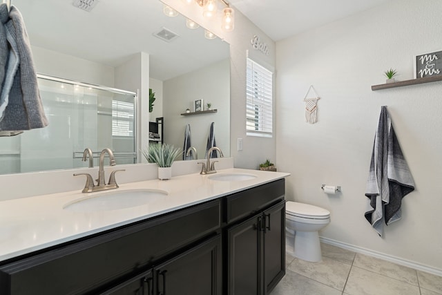 bathroom with tile patterned flooring, vanity, a shower with door, and toilet