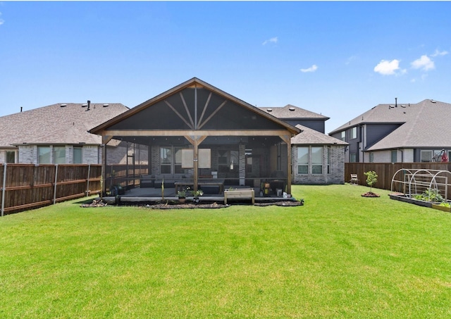 back of property with a lawn and a sunroom