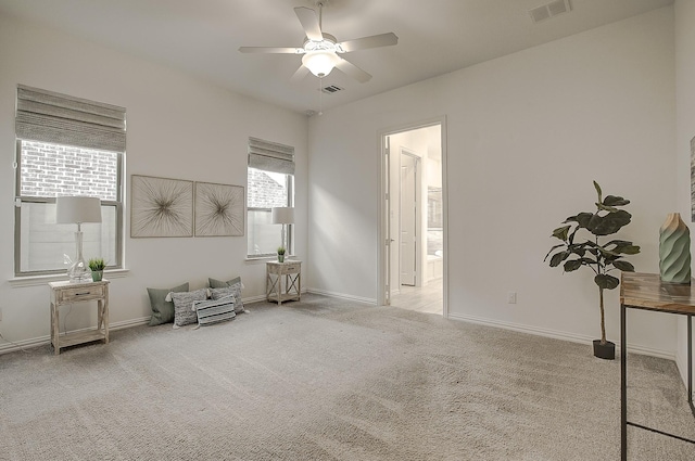 living area with ceiling fan and light carpet