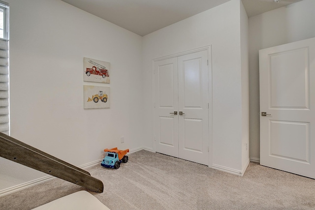 bedroom featuring light carpet and a closet