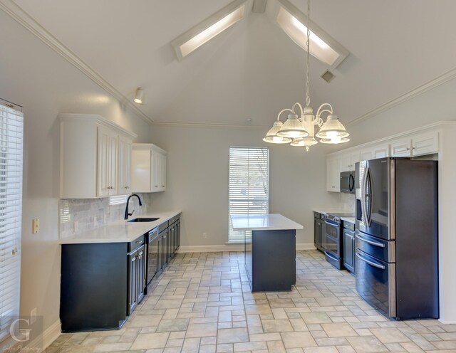 kitchen featuring sink, appliances with stainless steel finishes, a chandelier, and white cabinetry