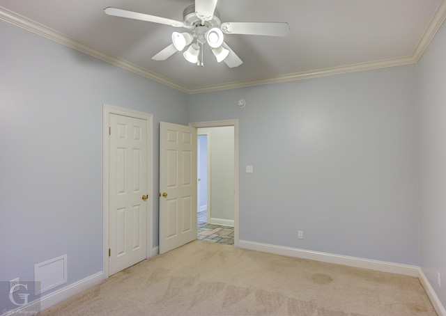 spare room with ornamental molding, ceiling fan, and light colored carpet