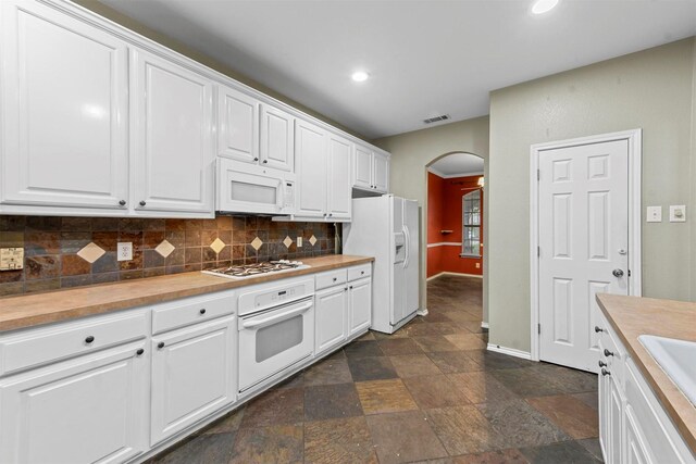 kitchen with white cabinets, white appliances, sink, and backsplash