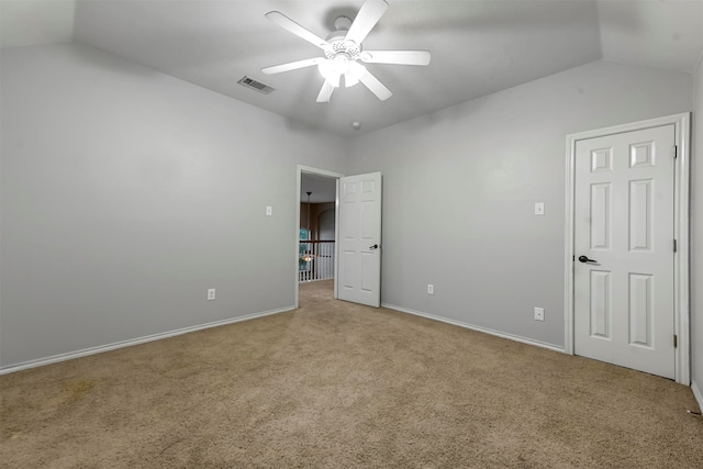 unfurnished bedroom with ceiling fan, light colored carpet, and vaulted ceiling