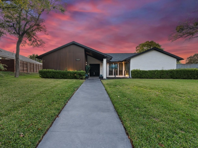 single story home with a lawn