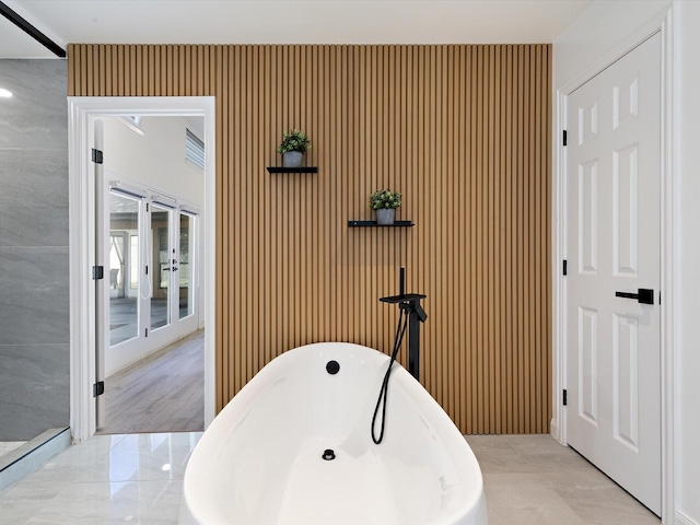 bathroom featuring french doors and a bathtub