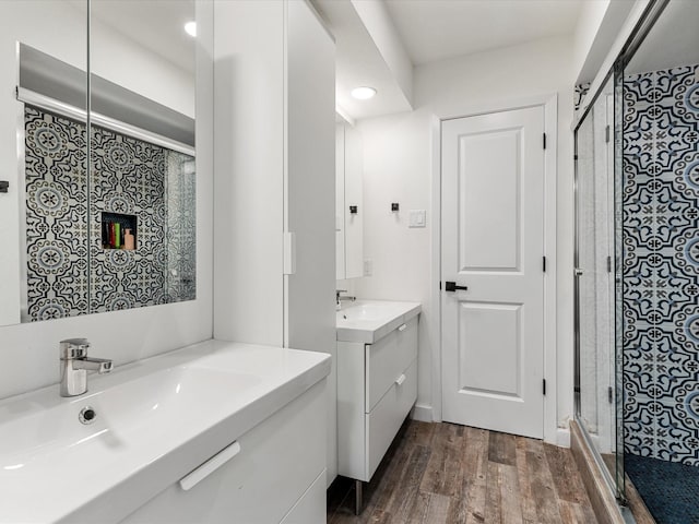 bathroom featuring hardwood / wood-style floors, vanity, and a shower with door