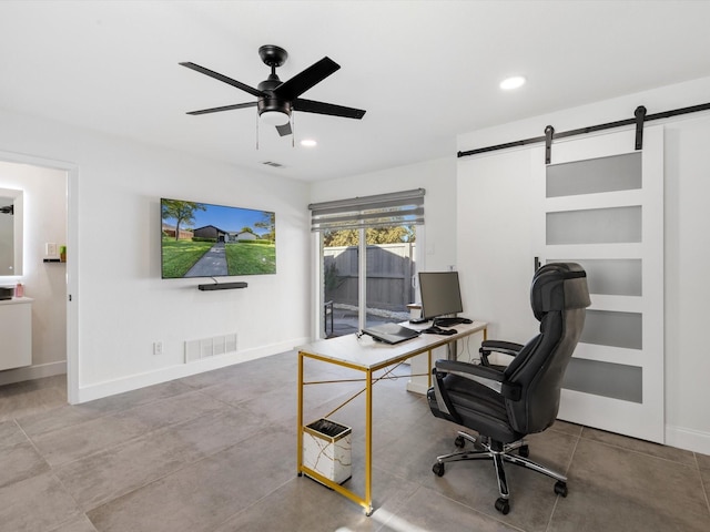 office with ceiling fan and a barn door