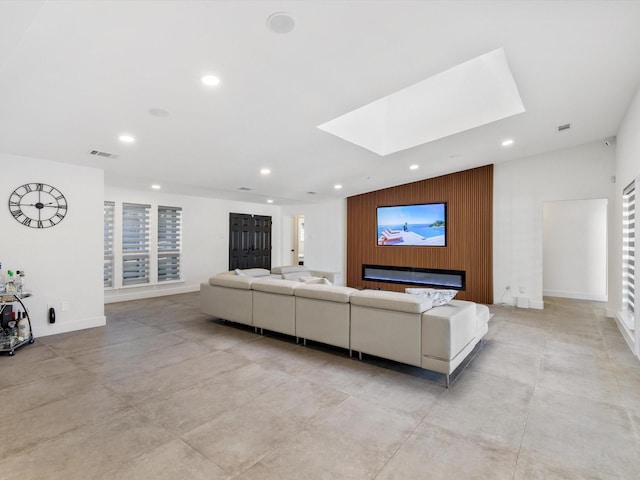 living room featuring a skylight and wood walls