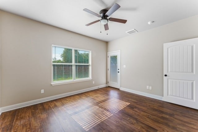 empty room with dark hardwood / wood-style floors and ceiling fan