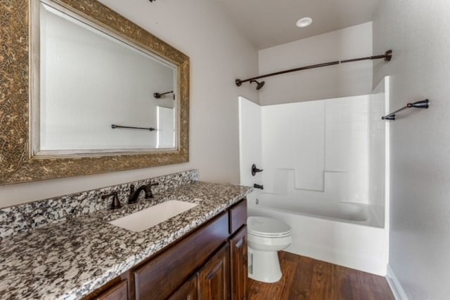 full bathroom with wood-type flooring, vanity, toilet, and shower / bathtub combination