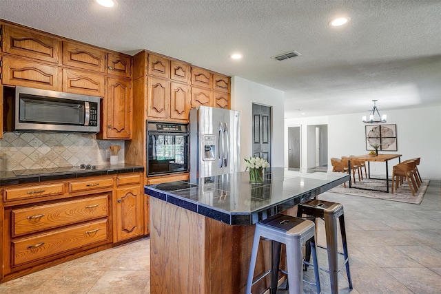 kitchen featuring backsplash, a center island, an inviting chandelier, a kitchen breakfast bar, and stainless steel appliances