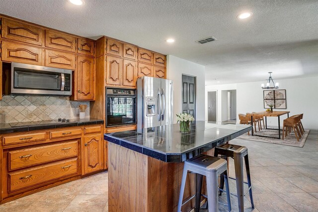 dining room featuring a textured ceiling, an inviting chandelier, sink, light tile patterned floors, and a barn door