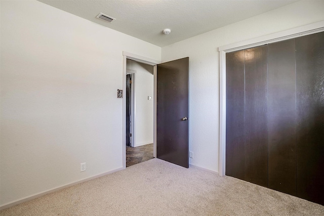 unfurnished bedroom with a closet and dark carpet