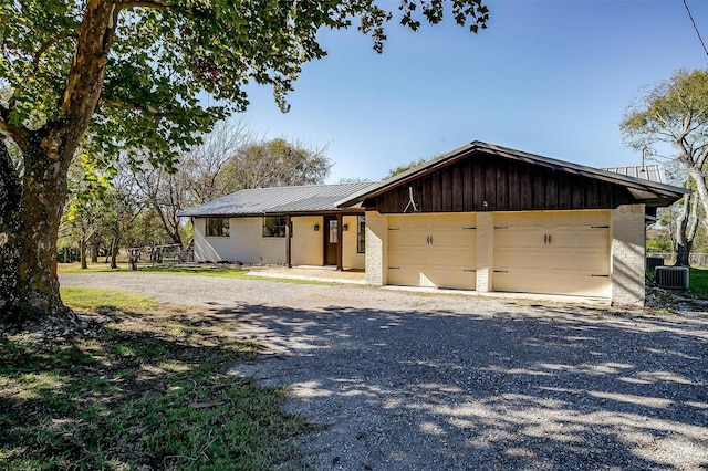 view of front of house with a garage and cooling unit