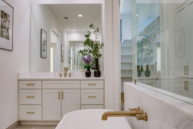 bathroom featuring tile patterned floors, vanity, and shower with separate bathtub