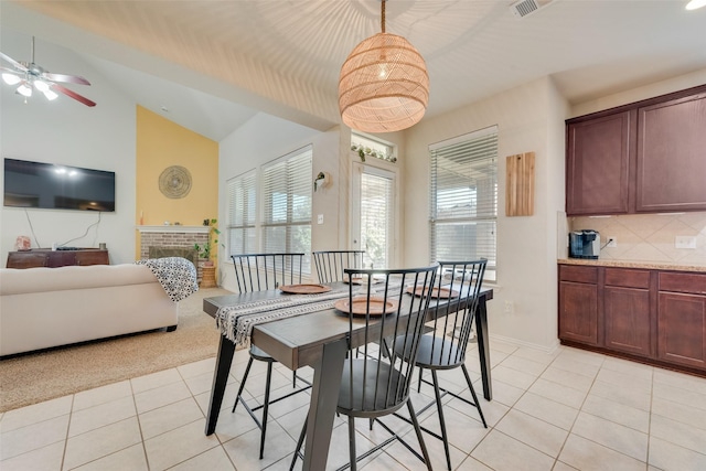 carpeted dining space featuring ceiling fan, a fireplace, and vaulted ceiling