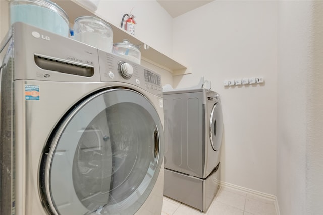 laundry area featuring light tile patterned floors and washing machine and dryer