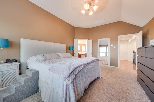 bedroom with ensuite bathroom, ceiling fan, light colored carpet, and lofted ceiling