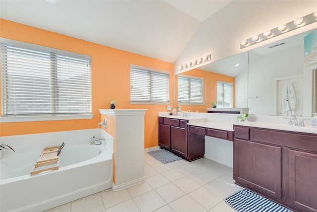 bathroom featuring tile patterned floors, vaulted ceiling, plenty of natural light, and a tub