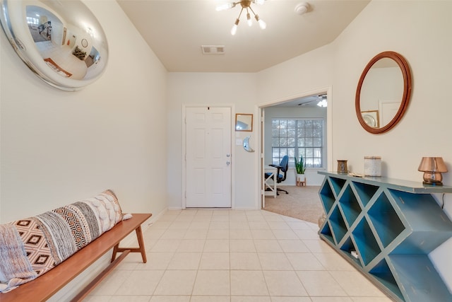 tiled entryway with an inviting chandelier