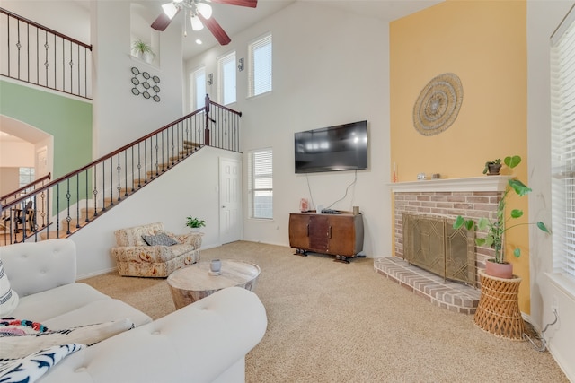 living room with carpet, a towering ceiling, and a healthy amount of sunlight