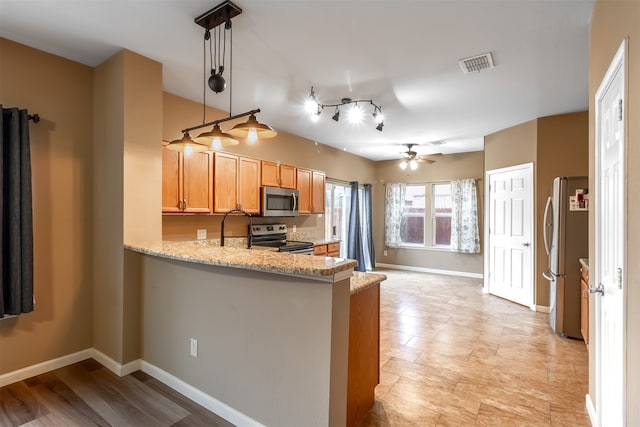 kitchen featuring ceiling fan, light stone countertops, kitchen peninsula, decorative light fixtures, and appliances with stainless steel finishes