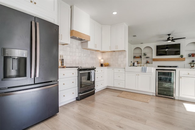 kitchen featuring white cabinets, custom range hood, stainless steel appliances, and wine cooler