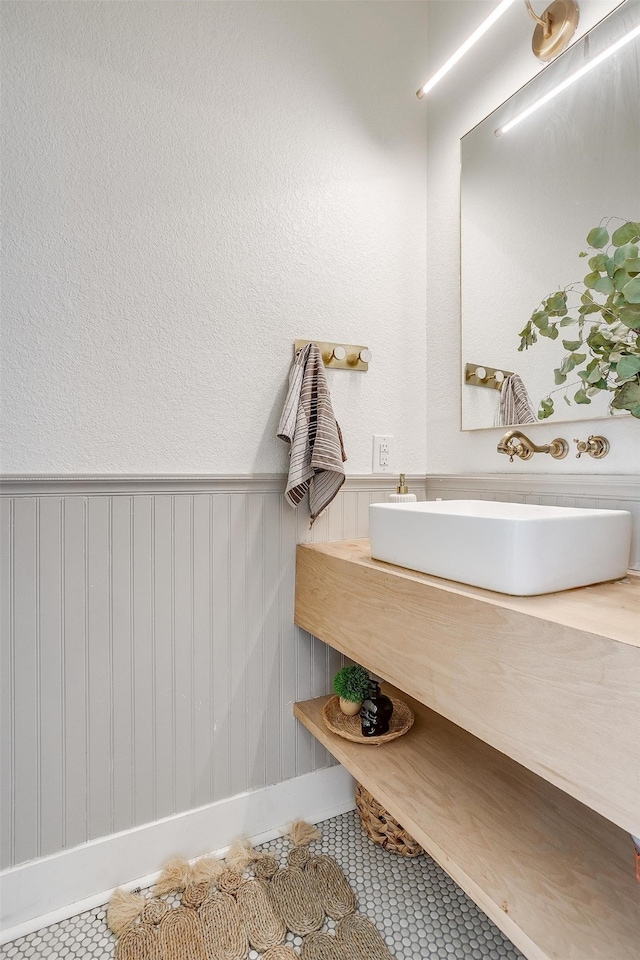 bathroom featuring vanity, tile patterned floors, and wood walls