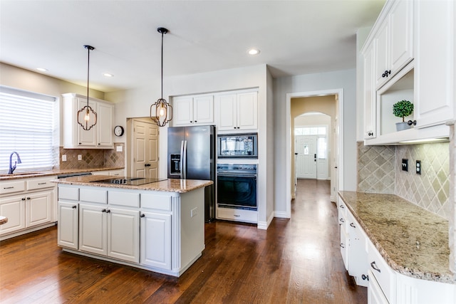 kitchen featuring black appliances, dark hardwood / wood-style floors, a kitchen island, and white cabinets