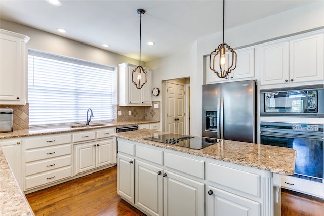 kitchen with sink, black appliances, white cabinets, dark hardwood / wood-style flooring, and decorative light fixtures