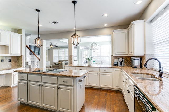 kitchen with white cabinetry, sink, light stone counters, and black appliances