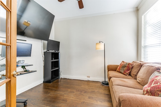 living room featuring dark wood-type flooring, ornamental molding, and ceiling fan