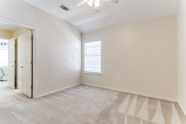 carpeted spare room with ceiling fan and vaulted ceiling