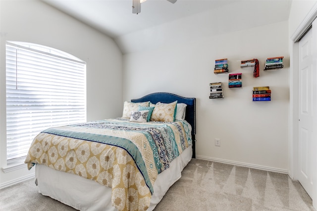 carpeted bedroom featuring ceiling fan, a closet, and vaulted ceiling