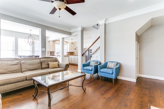 living room with ceiling fan with notable chandelier, dark hardwood / wood-style flooring, and ornamental molding