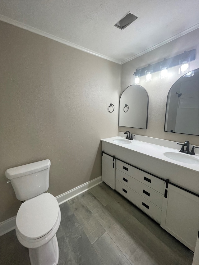 bathroom with wood-type flooring, vanity, toilet, and ornamental molding