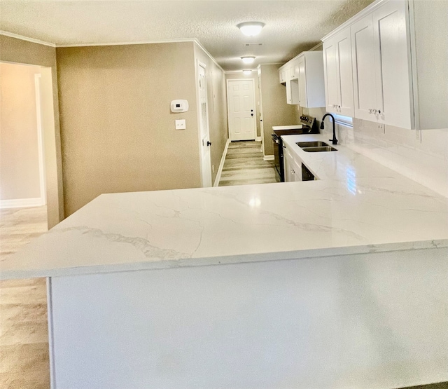 kitchen featuring white cabinetry, sink, kitchen peninsula, light hardwood / wood-style floors, and stainless steel range with electric stovetop