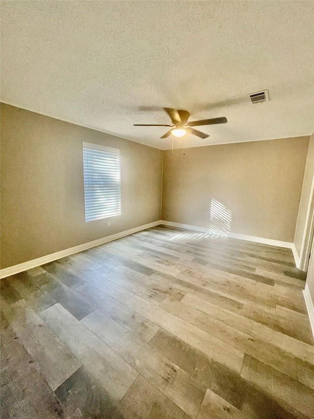 spare room with ceiling fan, a textured ceiling, and hardwood / wood-style flooring