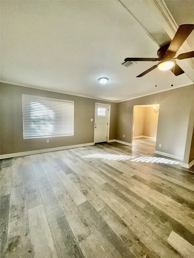 empty room featuring ceiling fan, light hardwood / wood-style floors, a textured ceiling, and ornamental molding