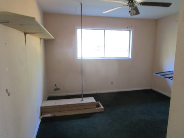 spare room featuring dark carpet and ceiling fan