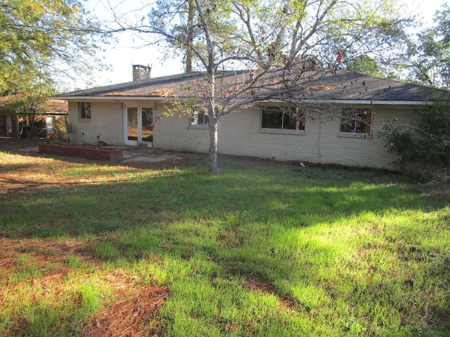 rear view of property with a yard