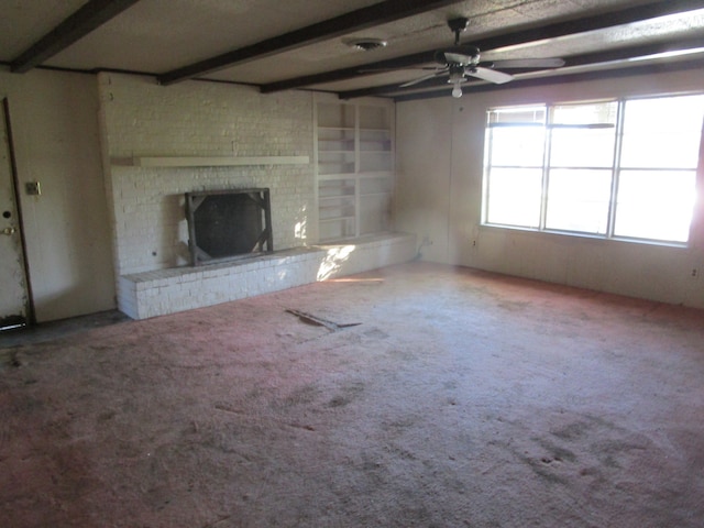 unfurnished living room featuring beam ceiling, ceiling fan, carpet flooring, and a brick fireplace