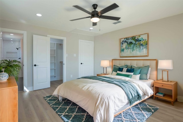 bedroom featuring a closet, ceiling fan, light hardwood / wood-style flooring, and a spacious closet