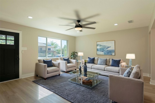 living room featuring ceiling fan and light hardwood / wood-style floors