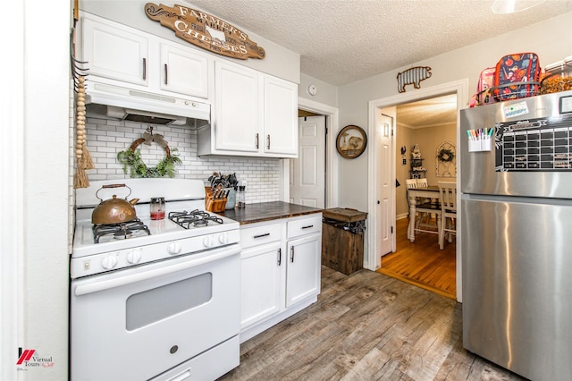 3756 Greenway Pl, Shreveport, LA 71105 - kitchen featuring freestanding refrigerator, white range with gas stovetop, under cabinet range hood, wood finished floors, and a textured ceiling