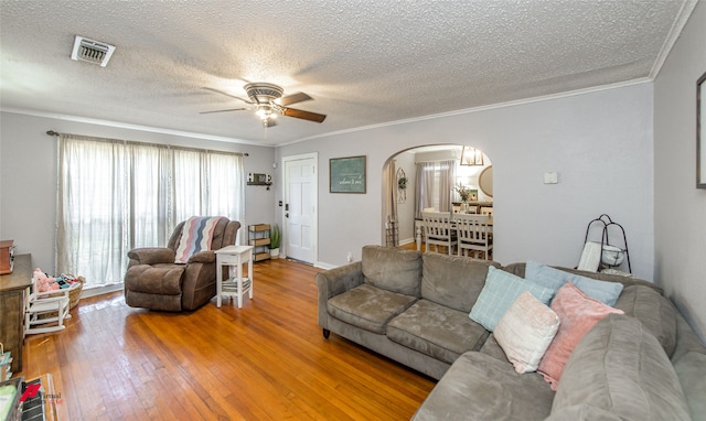 living room with hardwood / wood-style floors, ornamental molding, and a textured ceiling