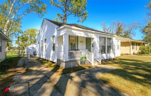 view of front of house with covered porch and a front lawn