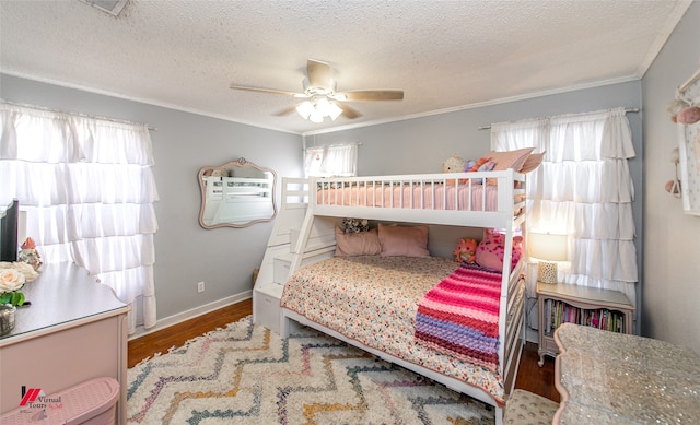 bedroom with ceiling fan, wood-type flooring, crown molding, and multiple windows