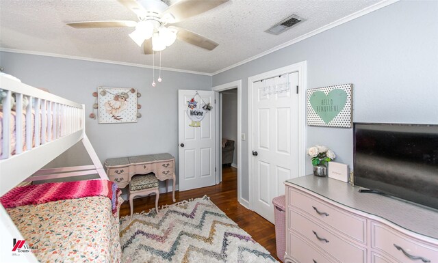 bedroom with ceiling fan, dark hardwood / wood-style floors, crown molding, a textured ceiling, and a closet